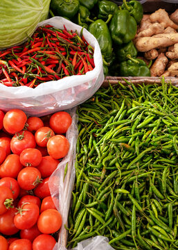 Tomatoes, green and spicy chili peppers on display at street food market in middle east