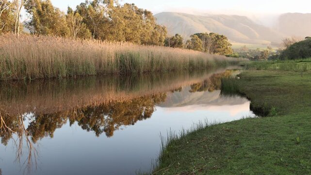 sunrise over beautiful reflections in the Klein River and Klein Mountains, Stanford, South Africa