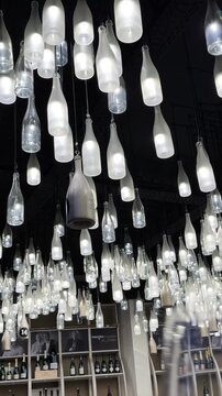 Champagne bottle lanterns hanging from the ceiling. Champagne tasting, Christmas in Reims, Champagne, France, December 25, 2025. High quality 4k footage
