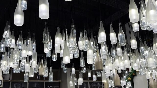 Champagne bottle lanterns hanging from the ceiling. Champagne tasting, Christmas in Reims, Champagne, France, December 25, 2025. High quality 4k footage