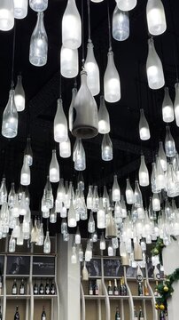 Champagne bottle lanterns hanging from the ceiling. Champagne tasting, Christmas in Reims, Champagne, France, December 25, 2025. High quality 4k footage
