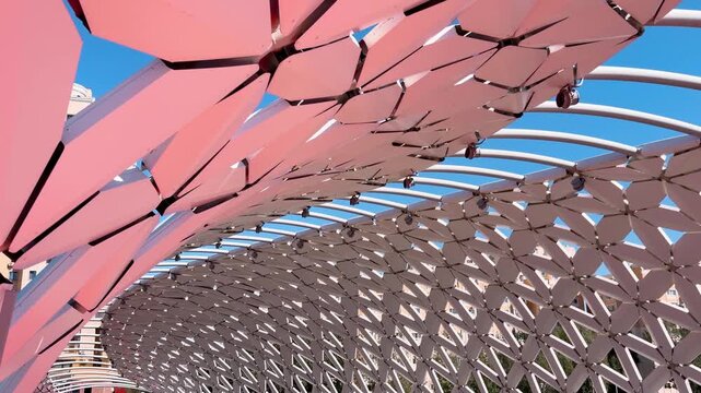 Atyrau Bridge in Astana, featuring curved white canopy, geometric metal panels, red pathway and modern architectural design, Kazakhstan, close-up details, shot handheld, 4k footage