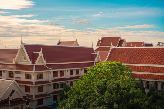 Traditional Thai temple rooftops with ornate gables under a blue sky
