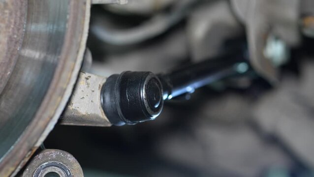 A brand new black suspension control arm installed on car.