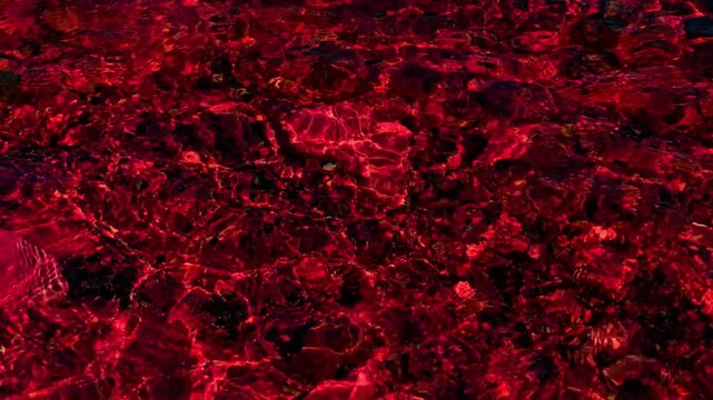 Rich red hues create an intricate, fluid pattern resembling liquid or molten material in constant motion.