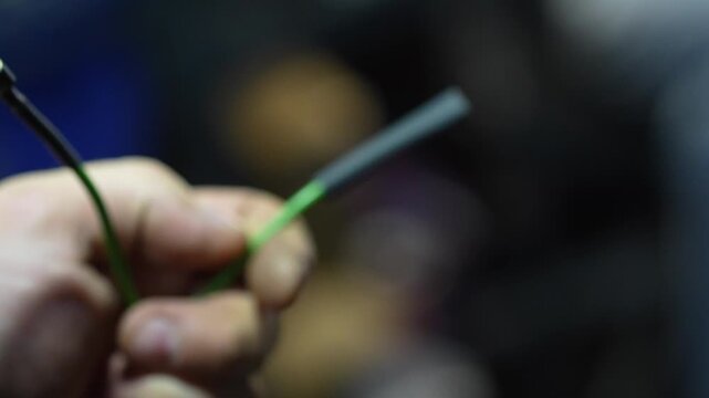 Mechanic uses a lighter flame to heat shrink automotive wire.