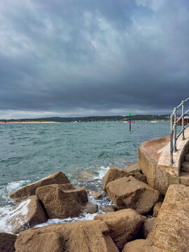 Coastal Sea Wall and Sandy Beach Under Stormy Clouds at Exmouth, Devon