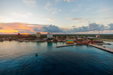 Obraz premium Cruise ships dock at Cozumel, Mexico's bustling cruise port, where turquoise Caribbean waters, vibrant coral reefs, and colorful seaside streets welcome visitors. Sunrise.
