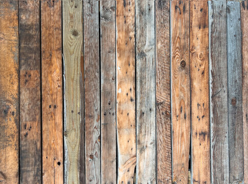 Rustic weathered wooden planks in varied natural brown, gray and beige tones forming a textured vintage background.