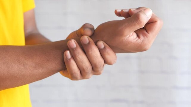 Close up view of young man suffering from wrist pain on white background, health care and medical concept, studio shot