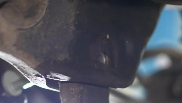 A threaded alignment bolt stud protruding from suspension bracket close-up.