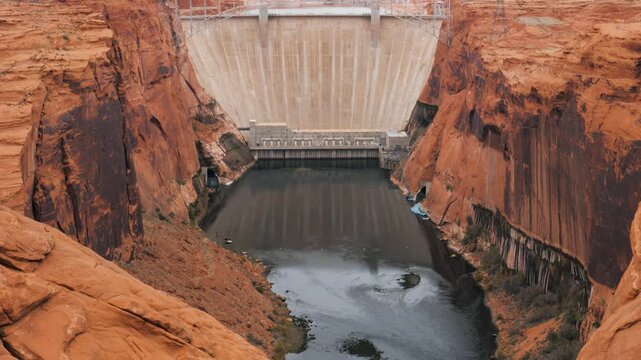 Majestic glen canyon dam. A concrete arch-gravity dam on the colorado river in northern arizona. Is a prominent landmark of the american west and a marvel of engineering in a desert canyon landscape