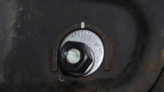 Close-up of a tightened car suspension eccentric camber bolt assembly.
