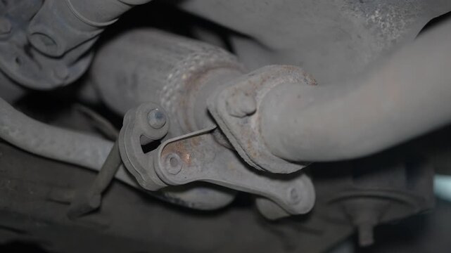 Close-up of a car exhaust flexible pipe and rubber hanger bracket.