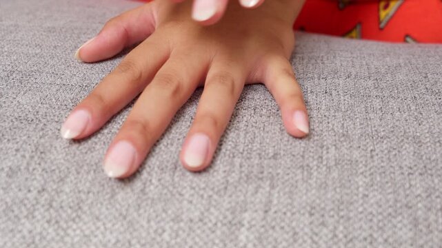 Woman's manicured hands gently caressing each other