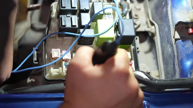 Close-up of multi colored fuses and relays inside fuse box.