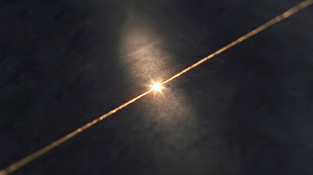 Single golden thread shimmering with light and dust particles against a dark, textured background.