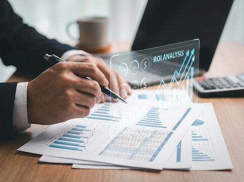 Businessman analyzing financial documents with roi data projection on wooden desk in office.