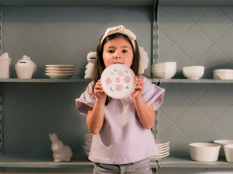 Little girl is showing souvenir she made for parents