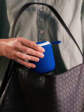 Woman taking wireless speaker from handbag