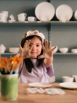 Girl showing her hands in paint