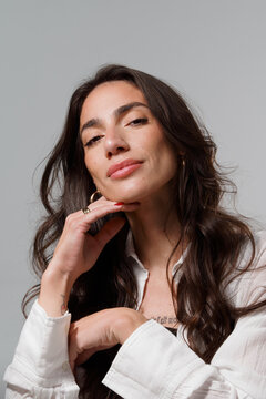 Woman Posing With Hand on Chin and Long Hair in Studio Setting
