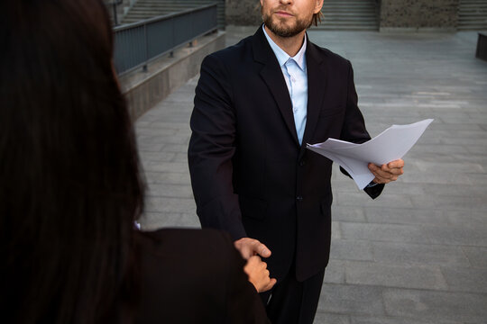 Business partners discussing contract outdoors