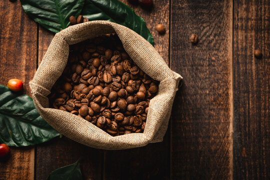 Roasted coffee beans spilling from burlap sack