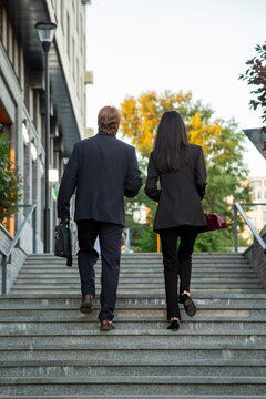 Business colleagues walking up city stairs together