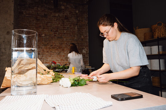 Florist Preparing Fresh Roses for Arrangement