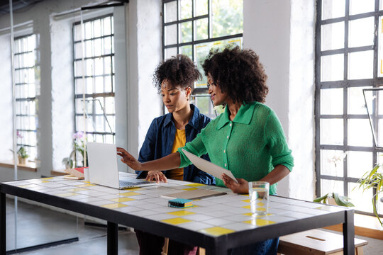 Two Female Colleagues Collaborating at Office Laptop