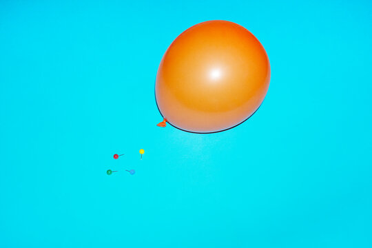 Balloon with spiky sharp push pins paper pins. Balloon about to pop