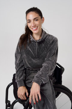 Woman in a Wheelchair Smiling While Wearing a Gray Outfit
