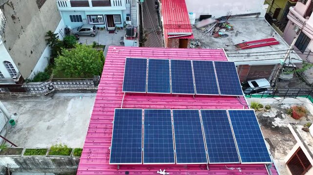 Aerial orbit of rooftop solar panels on Indian residential homes, capturing the rapid expansion of clean green renewable energy infra through the PM Surya Ghar initiative.