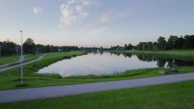 Fast and low drone flying over a small river at dusk