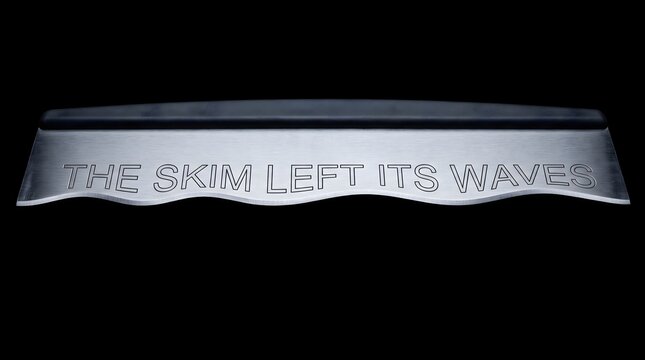 Metal scraper blade with the engraved phrase The Skim Left Its Waves