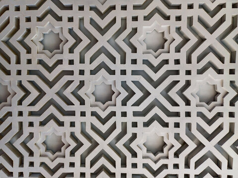 Full frame close up of white islamic geometric star pattern lattice wall carving texture. Arabesque architectural ornament backdrop mockup for design.