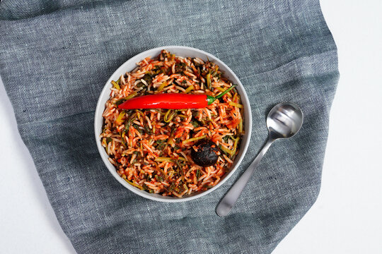 Overhead Flat Lay View of Middle Eastern Rice Dish Garnished with Fresh Red Chili Pepper in Ceramic Bowl