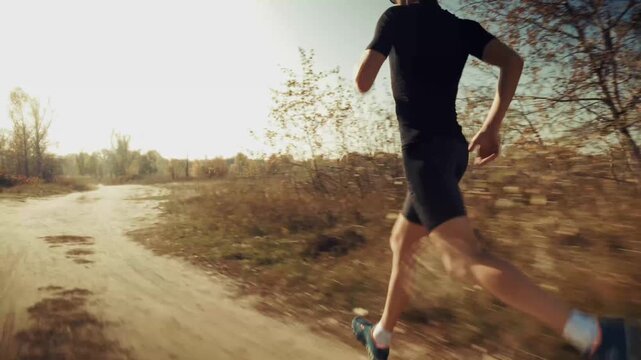 Runner Jogging On Dirt Country Road At Sunrise. Cardio Workout. Training Endurance