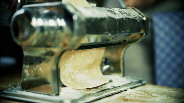 Fresh Dough Rolling Through Mechanical Pasta Machine. Homemade Noodle Making 