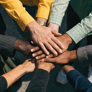 Diverse hands stacked together in a gesture of unity and teamwork