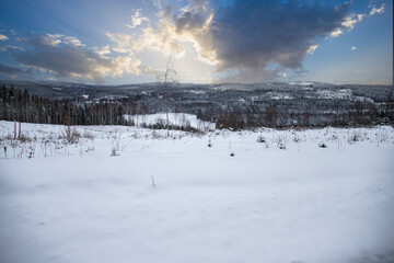 Fototapeta premium Panoramic view over snowy hills and endless winter forest landscape, Sweden