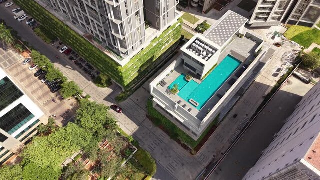 Residential apartment community with rooftop pool and landscaped greenery aerial real estate
