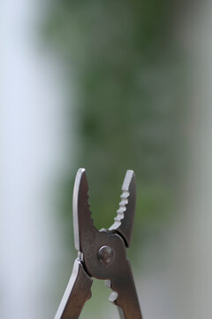 Vertical closeup of stainless steel pliers multi tool with copyspace for text