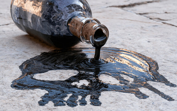 The Glass Bottle Spill A Dark Viscous Pour Creating a Skulllike Mark on Ground