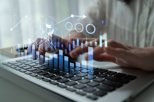 A close-up of hands typing on a laptop with an overlay of business charts and growth metrics, representing data analysis and success in a modern workspace environment. Nascent