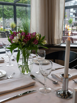 A beautifully arranged dining table in a fine dining restaurant, set for a romantic meal or special occasion. 