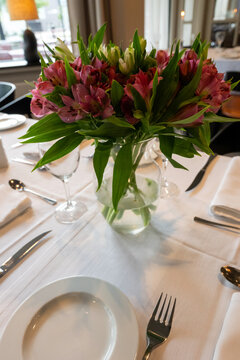 A beautifully arranged dining table in a fine dining restaurant, set for a romantic meal or special occasion. 