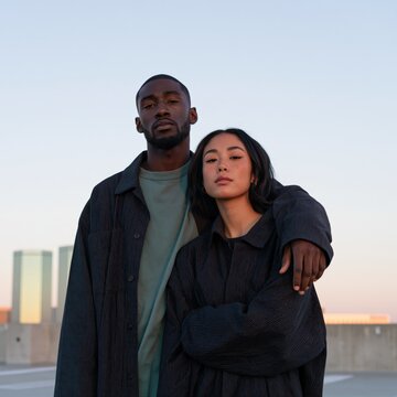 Urban couple portrait on a rooftop at sunset with casual fashion and skyline view for lifestyle background and modern city imagery