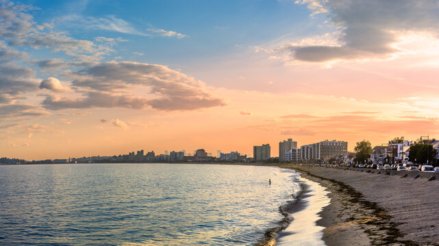 Revere Beach and the Revere, Massachusetts skyline at sunset, with a golden evening sky, calm coastal waters, and a scenic Atlantic shoreline.